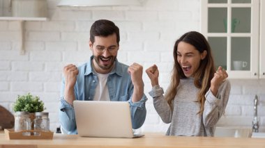 Heyecanlı genç çift başarıyı kutluyor, e-postada iyi haberler okuyor.