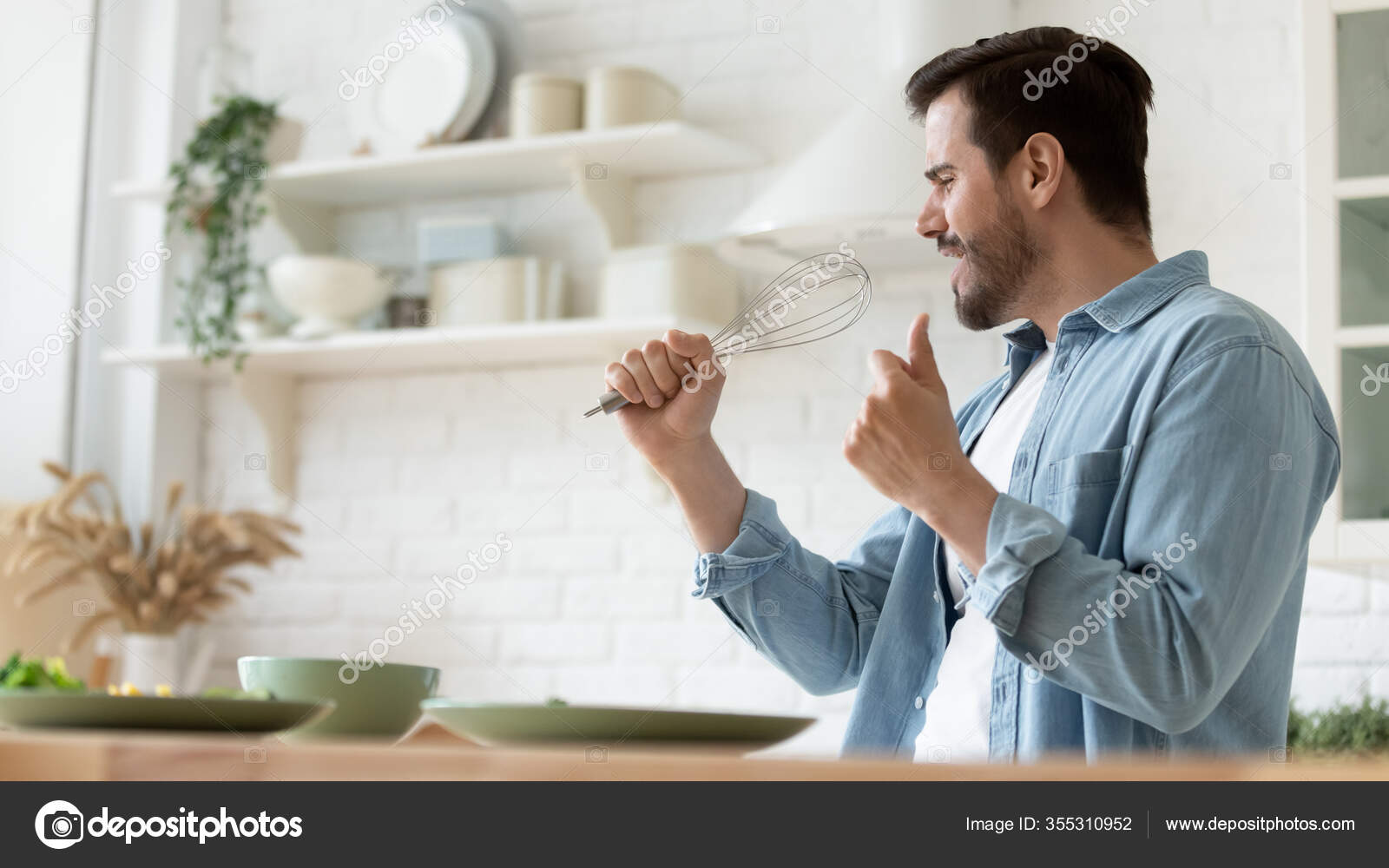 Divertido hombre guapo cantando en whist, divertirse en la cocina
