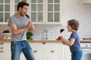 Mutlu baba ve küçük oğul evde şarkı söylerken eğlenin.