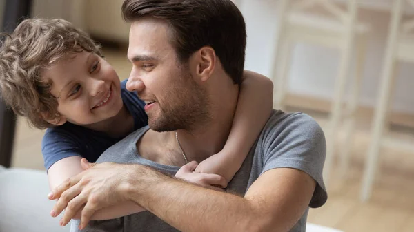 Lachende jonge vader en zoon knuffel ontspannen thuis — Stockfoto