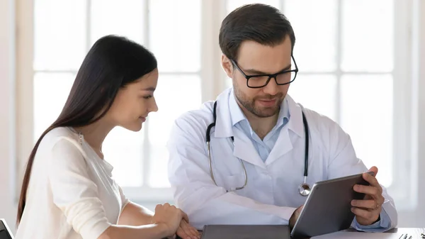 Angenehmer Arzt teilt Behandlungsideen mit junger Frau. — Stockfoto