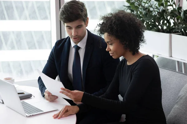 Diverse Kollegen sitzen am Schreibtisch im Büro und arbeiten gemeinsam am Computer — Stockfoto