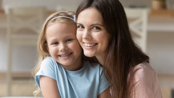 Porträtt av leende mamma och dotter titta på kameran kramas — Stockfoto