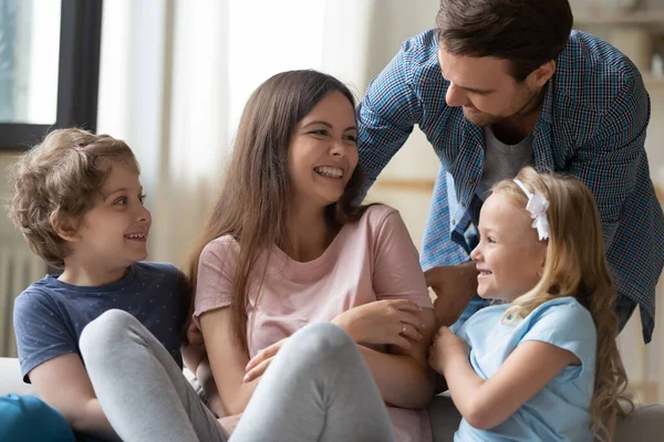 Neşeli genç aile evde birlikte rahatlarken iyi eğlenceler.
