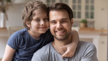 Gülümseyen genç baba ve oğul kucaklaşması portresi