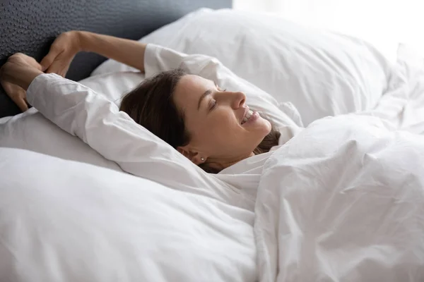 Smiling brunette lady enjoying good holiday time after wake up.