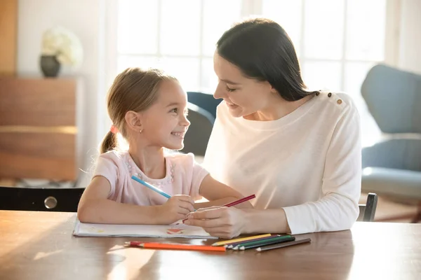 Niñera sonriente desarrollando habilidades de dibujo de niña . —  Fotos de Stock