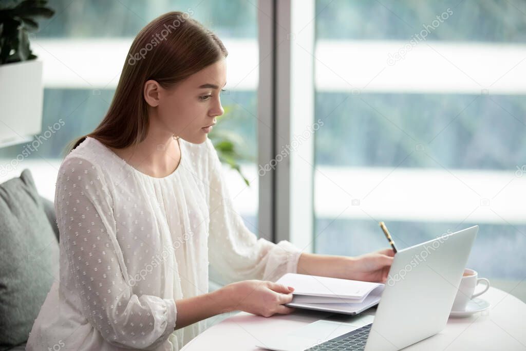 Concentrated female employee busy working on laptop