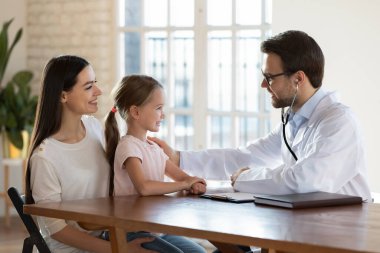 Erkek doktor küçük şirin hasta omzunda el ele tutuşuyor..