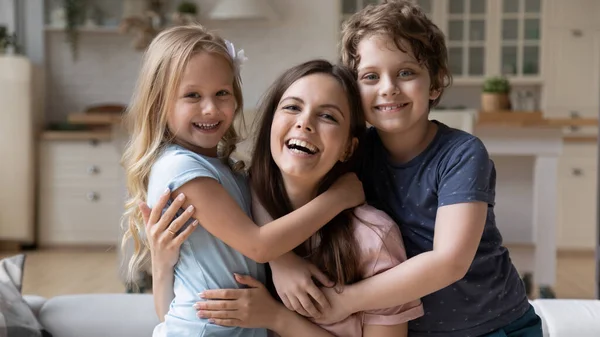Portrait of happy young mom cuddling with small kids — Stock Photo, Image