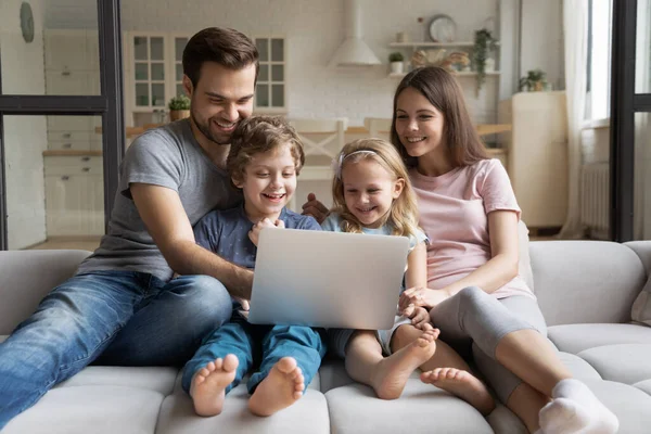 Overjoyed jovem família com crianças usando laptop juntos — Fotografia de Stock