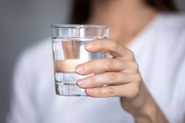 Фокус на стакане чистой дистиллированной воды в женских руках . — стоковое фото