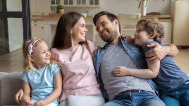 Çocukları evde dinlenen mutlu, genç bir aile.