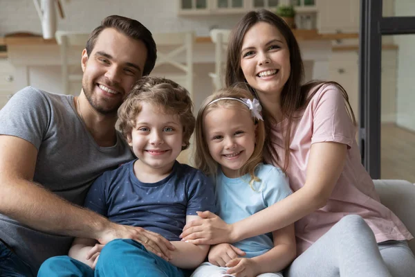 Kopfballporträt einer glücklichen Familie mit Kindern, die es sich auf der Couch gemütlich macht — Stockfoto