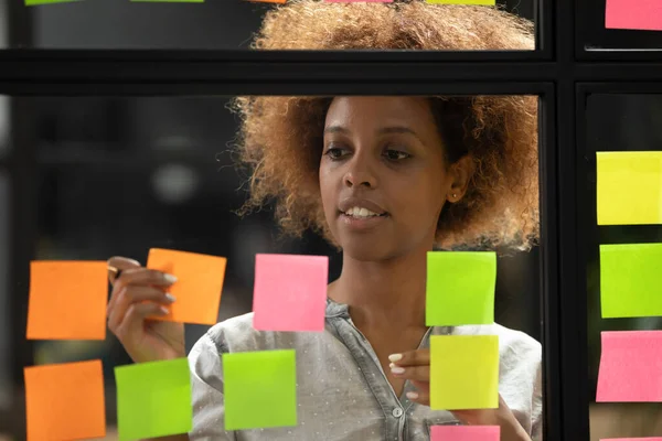 African American businesswoman working on project plan using sticky papers — Stock Photo, Image