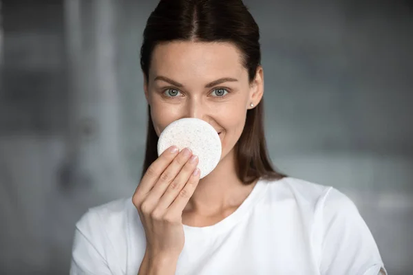 Pretty brunette woman cleansing nose with sponge. — Stock Photo, Image