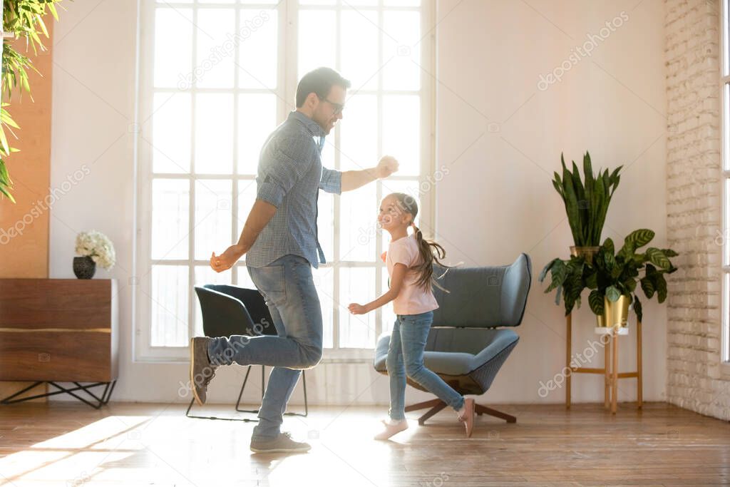 Happy young father dancing with adorable small daughter.