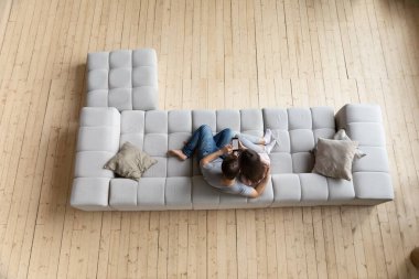 Çiftin üst görüntüsü koltukta cep telefonuyla rahatlıyor.