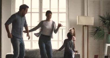 Mutlu genç evli çift çocuklarla müzik eşliğinde dans ediyor..