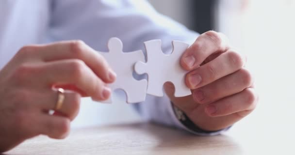 Empresário conectando duas peças de quebra-cabeça juntos, vista de perto — Vídeo de Stock