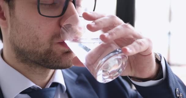 Hombre de negocios saludable lleva traje sosteniendo el agua potable de cristal, de cerca — Vídeos de Stock