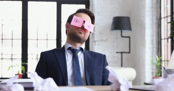 Vtipný podnikatel spí na pracovišti s lepkavými poznámkami na tváři — Stock video