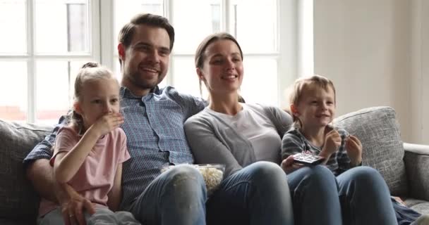 Mujer bonita feliz viendo la televisión con el marido y los niños . — Vídeo de stock