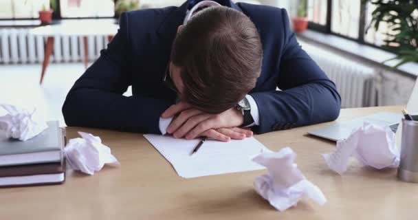 Втомився бізнесмен перестає спати за безладному офісному столі з паперами — стокове відео