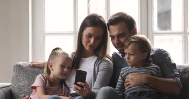 Mutlu aile akıllı telefondan komik videolar izliyor..