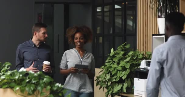 Lächelnde multiethnische Kollegen treffen männliche Kollegen im Flur. — Stockvideo