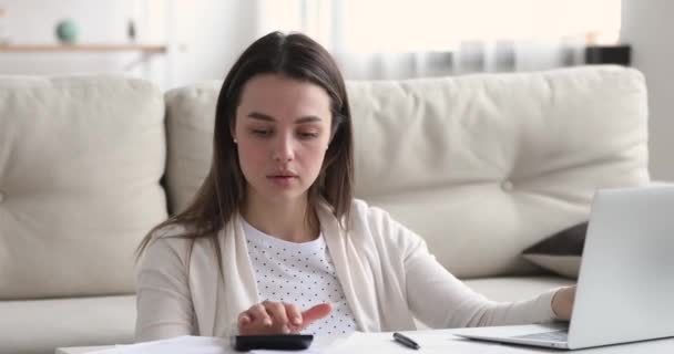 Millennial woman holding paper bank receipt calculating taxes or bills — Stock Video