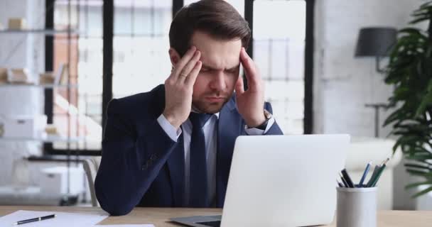 Erschöpfte gestresste Frau leidet unter Kopfschmerzen am Arbeitsplatz — Stockvideo