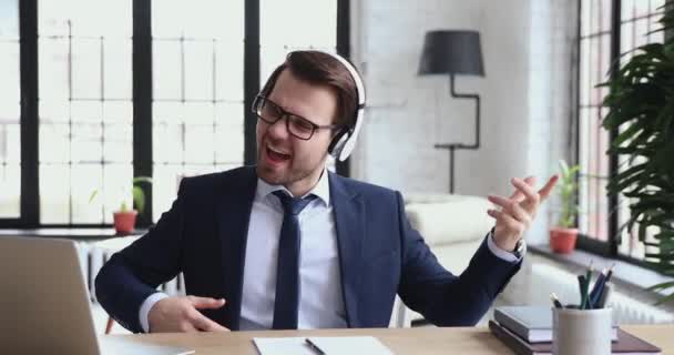 Empresário animado ouvindo música fingindo tocar guitarra no escritório — Vídeo de Stock