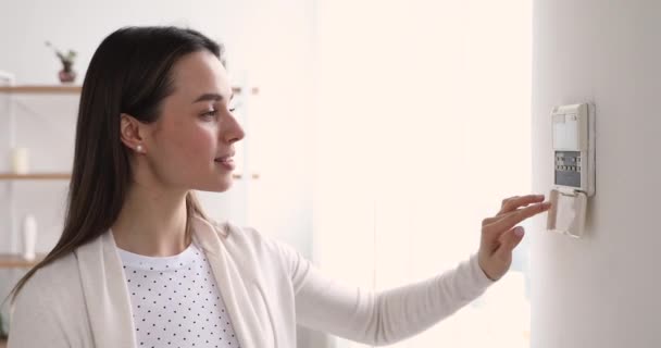 Genç kadın akıllı ev güvenlik sistemi konseptini ayarlıyor — Stok video