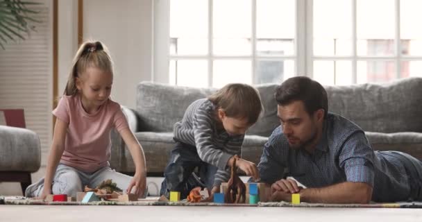 Šťastné malé děti stavět budovu s otcem doma. — Stock video