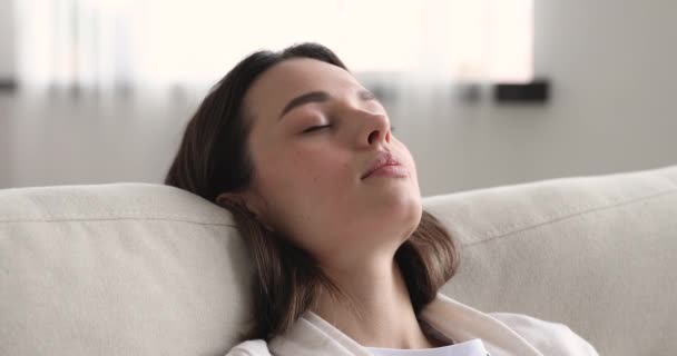 Nyugodt fiatal nő szunyókál dőlve alszik kényelmes kanapén — Stock videók