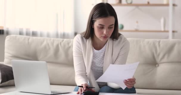 Mujer joven usando calculadora portátil calcular el pago de facturas en línea — Vídeos de Stock