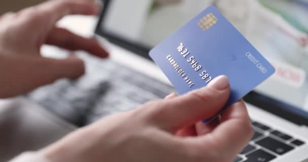 Cliente feminino segurando cartão de crédito pagando on-line no laptop, close-up — Vídeo de Stock
