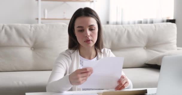 Mujer joven preocupada molesto leyendo malas noticias en carta de papel — Vídeos de Stock