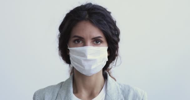 Mujer joven lleva máscara facial médica que muestra gesto stop hand — Vídeos de Stock