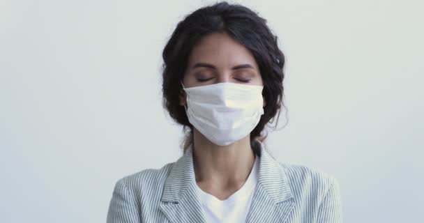 Mujer joven respirando usando mascarilla médica mirando la cámara — Vídeo de stock