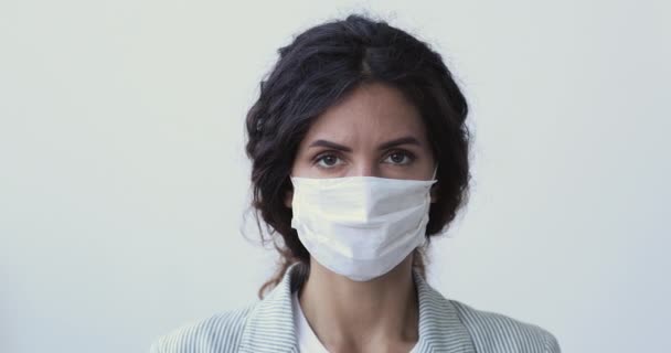 女性は、停止コロナウイルスの手ジェスチャーを示す医療用マスクを身に着けている — ストック動画