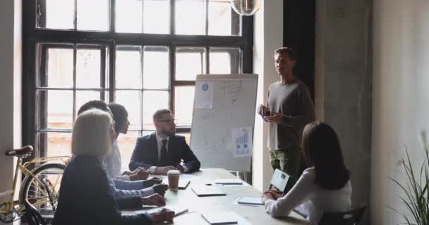 Junge Moderatorin erklärt konzentrierten Geschäftsleuten Ergebnisse der Marketingforschung. — Stockvideo