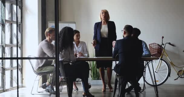 Motivated colleagues listening to older leader, explaining project details. — Stock Video