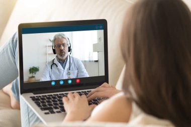 Web kamerası ve dizüstü bilgisayar kullanarak doktorla uzaktan iletişim kuran kız