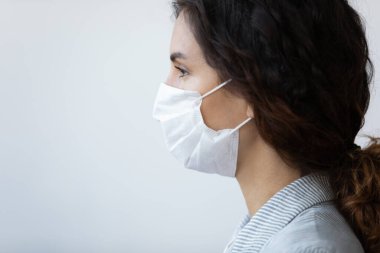 Koruyucu tıbbi maskeli bir kadının profil görüntüsü