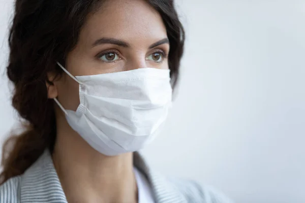 クローズアップ画像女性で顔の医療マスク上の青の背景 — ストック写真
