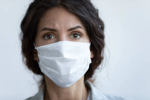 Su sfondo blu studio primo piano interessato donna faccia in maschera — Foto Stock