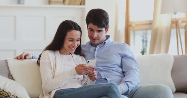 Emocionada pareja ganando el premio sorteo en las redes sociales en el teléfono inteligente — Vídeo de stock