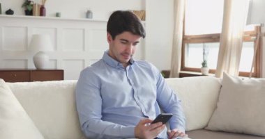 Neşeli adam elinde akıllı telefonla gezici spor bahislerini kutluyor.